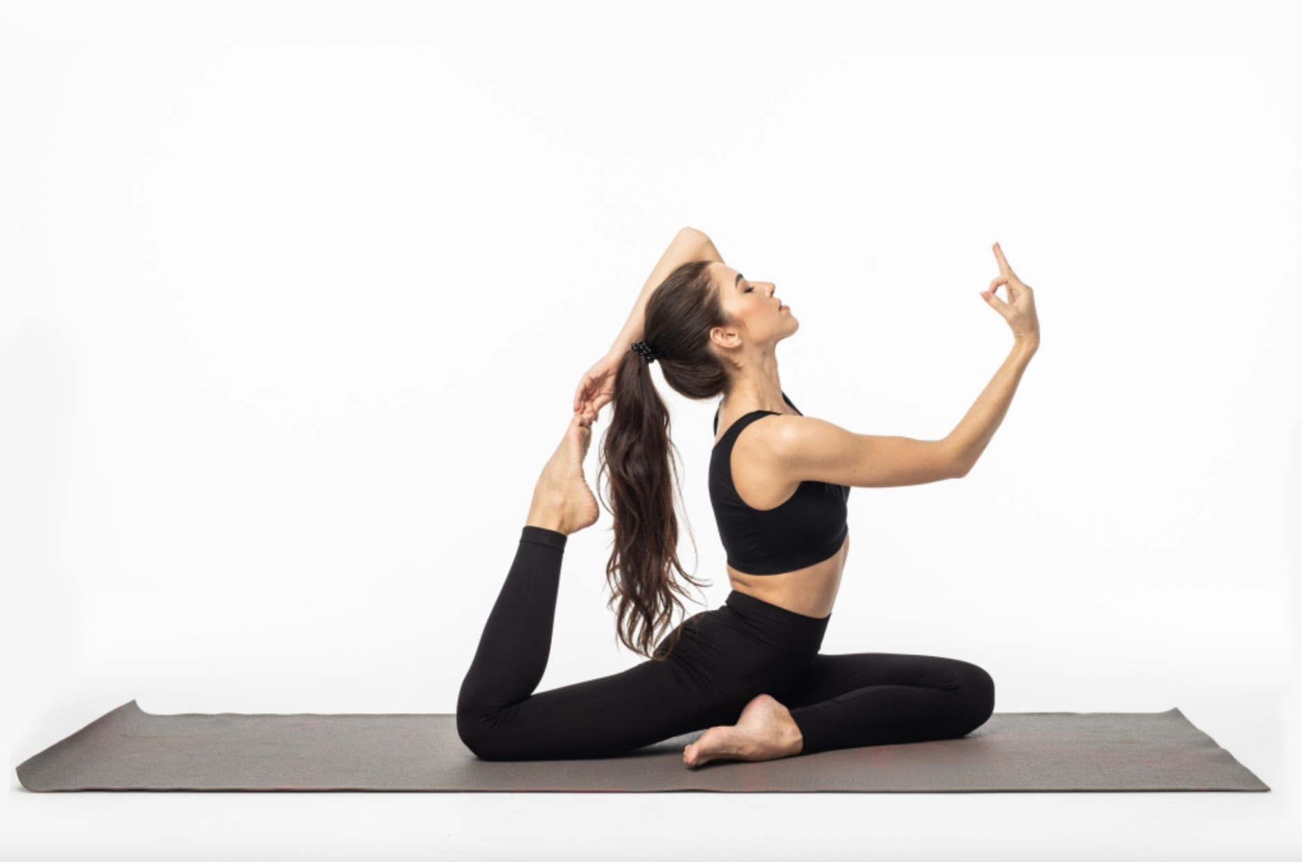 Imagen de una chica haciendo la postura de la garza en yoga sobre un tapete