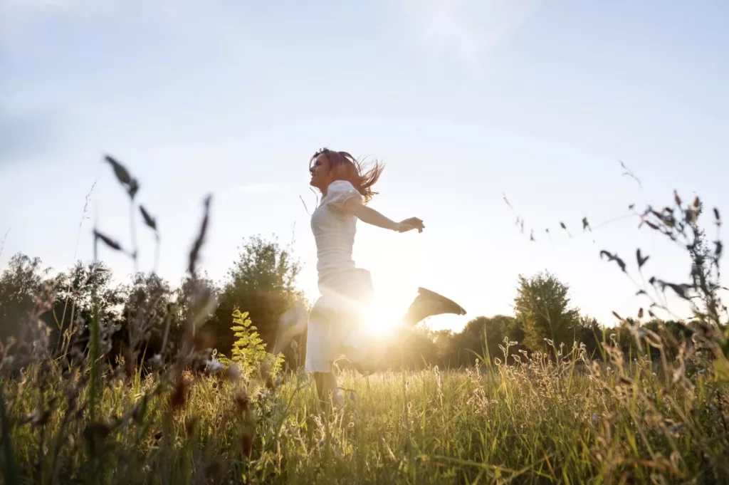 chica corriendo feliz por el campo