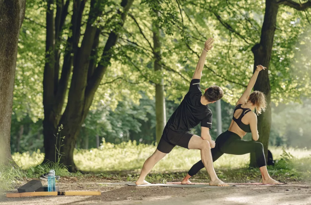 hombre y mujer realizando posturas de yoga