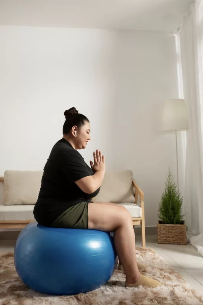 Chica sentada en una pelota azul